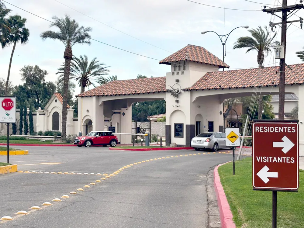Entrada de un fraccionamiento cerrado con caseta de vigilancia